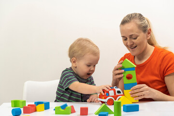 Mom and son play cubes and laugh at the bright background. high quality
