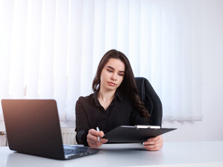 Young businesswoman checking tasks in her office.