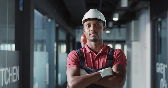 Zoom portrait of african heavy industry electricity worker smiling confident for camera while coworking on construction site.