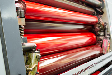 Color and glossy rollers of Komori offset printing machine. offset ink colour. magenta, red. - obrazy, fototapety, plakaty