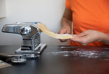 Roll out the pasta dough with the machine at home. making pasta