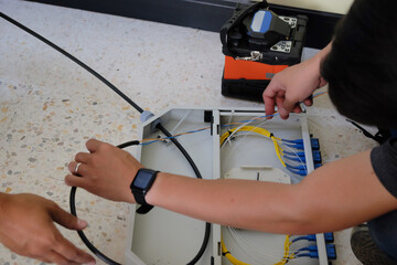 Technicians are cutting and fusion fiber optic cables.
