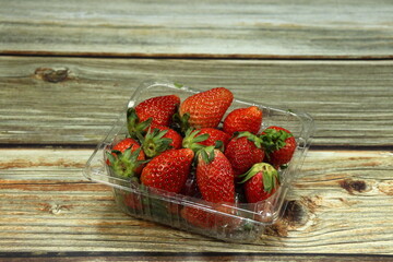 Pile of fresh and organic strawberry serving in the plastic tray. Product ready to sale in market concept. 