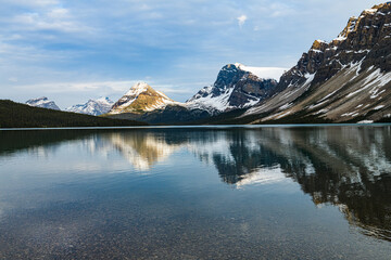 Calm water reflecting the surrounding Canadian Rockies  at Bow Lake in Banff National Park Canada
