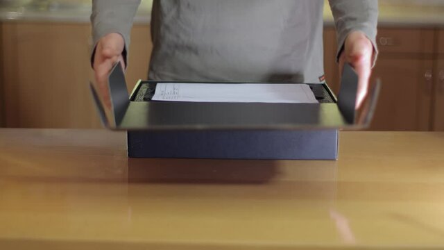 Shop assistant showing a blank black box of computer hardware equipment for buying, distributor office, packing the product with receit