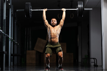 Naklejka premium Muscular athlete lifting very heavy barbell