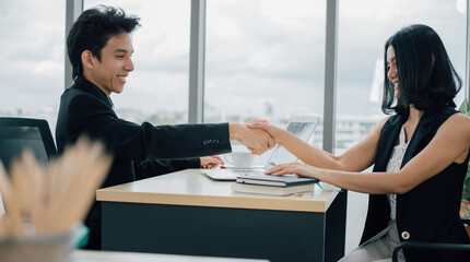 Business partners shaking hands together to start up small business in office room.