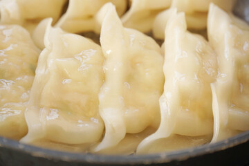 フライパンで調理中のギョウザ