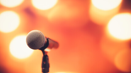 Public speaking backgrounds, Close-up the microphone on stand for speaker speech presentation stage performance with blur and bokeh light background.