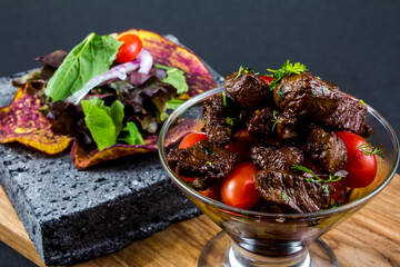 Sliced grilled beef barbecue steak and salad with tomatoes and arugula