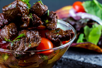 Sliced grilled beef barbecue steak and salad with tomatoes and arugula