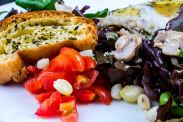 Portion of chicken lasagna garnished with salad greens