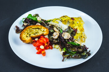 Portion of chicken lasagna garnished with salad greens