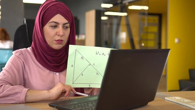 Muslim woman teacher working remotely. Online chat with students  using laptop and webcam, math lesson. Distance learning, Remote work, freelance. Covid-19 lockdown