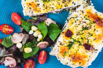 Vegetarian lasagne topped with toasted pine nuts and melting cheeses. Salad