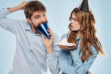 Cheerful man and woman with cake in a plate corporate party blue background