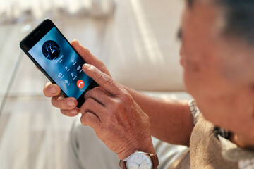Old man accepted call with unknown person by smart phone at home, scam phone on elderly person.