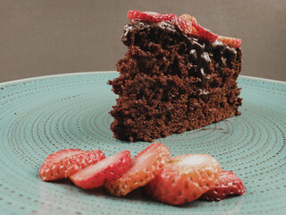 chocolate cake with strawberries in turquoise dish