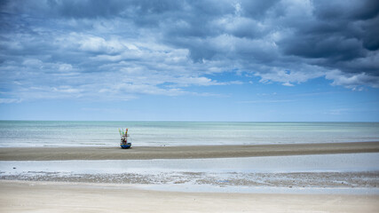 Fototapeta na wymiar a boat was on the shore with cloudy sky, Hua Hin Thailand