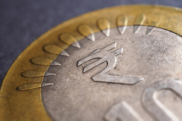 Translation of the inscription: rupee. Fragment of Indian 10 rupee coin with the sign of the national currency close up. Illustration on the theme of money, economy, finance and banks in India. Macro