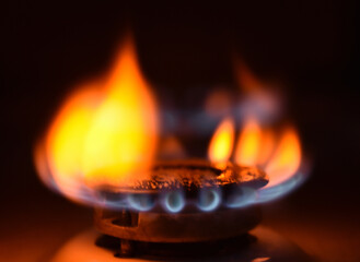  Round orange blue burning gas flame black background close up