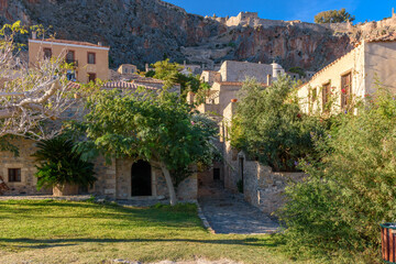 Fototapeta premium Traditional architecture with narrow stone street and a colorfull bougainvillea in the medieval castle of Monemvasia, Lakonia, Peloponnese, Greece. 