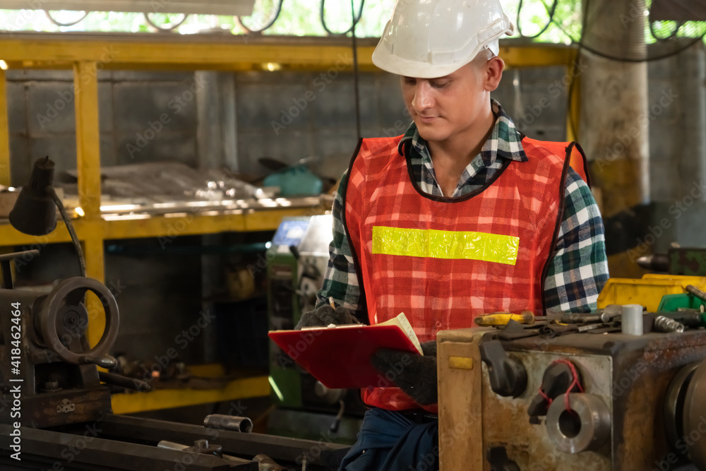 Poster manufacturing worker working with clipboard to do job procedure checklist . factory production line 