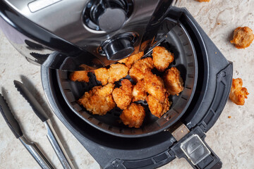 Close up flat lay image of an air fryer oven on kitchen countertop. This offers fast and easy...