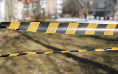 Orange and black tapes of outdoor area fencing. Close-up, selective focus