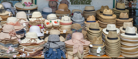 Collection of Hats on display for sale to tourists on  local souvenir shop . Street sale of hats.