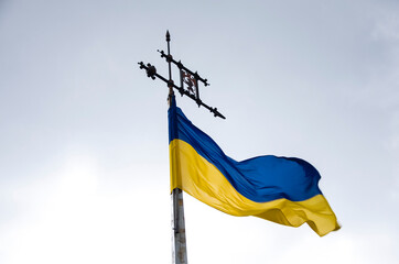 Ukrainian flag fluttering in the wind on a flagpole with a weather vane 