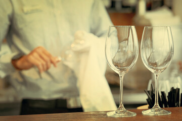 Obraz na płótnie Canvas Bartender wipes the wine glasses