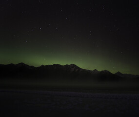 Big Dipper stars over Alaskan mountains with Aurora