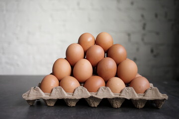 Pyramid of chicken eggs on a white wall background