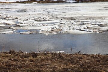 Seasonal spring ice drift in Europe, a view from the shore of the floating ice on the river water...