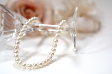 パールネックレスと、ワイングラスとコサージュ