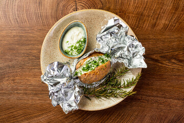 Potatoes baked in foil and white sauce 