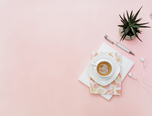 Pastel office desk table with notebook, coffee and supplies. Top view with copy space, flat lay.