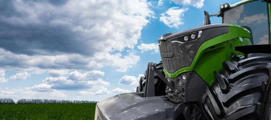 Fotobehang Groene tractor op een landbouwgebied © scharfsinn86