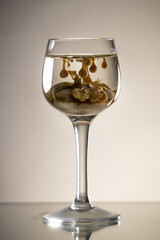 Reverse irish cream monkey brain shot drink in old fashioned elegant glass, stands on reflective surface. Gradient background