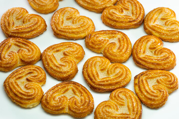 Selective focus of little heart shaped biscuits on a white background.