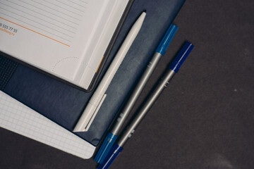 notepads pens office supplies desktop work gray background