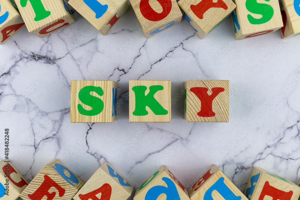 Fototapete sky concept with colorful alphabet letters on wooden cubes centered between top and bottom borders o