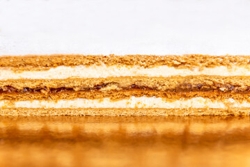 Honey cake on orange plate. Layered honey cake. Closeup view