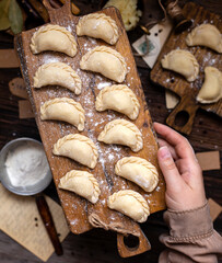 homemade raw dumplings on wooden board. traditional ukrainian food. overhead shot