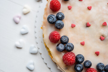 heart love carrot cake mothersday, valentines day, wedding cake with blueberries, raspberries, and heart sprinkles 