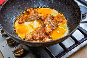 Meat and eggs are fried in a pan, close-up photo.