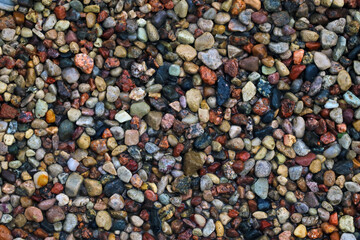 Top view of the beach with colorful stones, background.