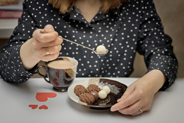 A young woman drinks coffee with dessert. The concept of Valentine's day