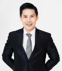 Young and handsome black hair Asian businessman in dark tone suit standing and looking to camera, pose with self-confidence and trust